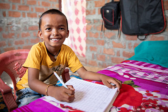 Shishir doing his homework at home in Kanchanpur, Nepal